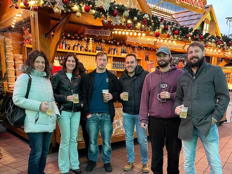 Kolleginnen und Kollegen von Hasieber am Weihnachtsstand mit Getränken