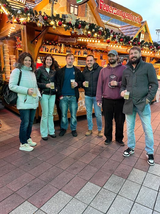 Kolleginnen und Kollegen von Hasieber am Weihnachtsstand mit Getränken