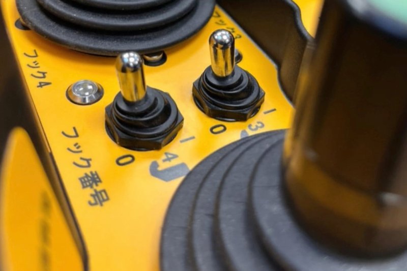Detailansicht Hetronic Funkfernsteuerung für Japan Nahaufnahme einer gelben Hetronic Funkfernsteuerung mit Schaltern und Joystick, entwickelt für ein Projekt in Japan
